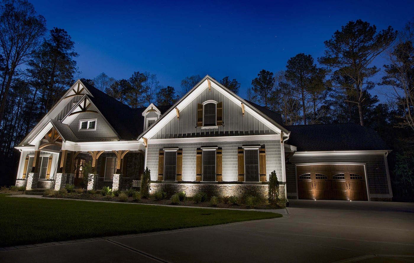 A home and its landscape illuminated by Bolt Outdoor Lighting at dusk